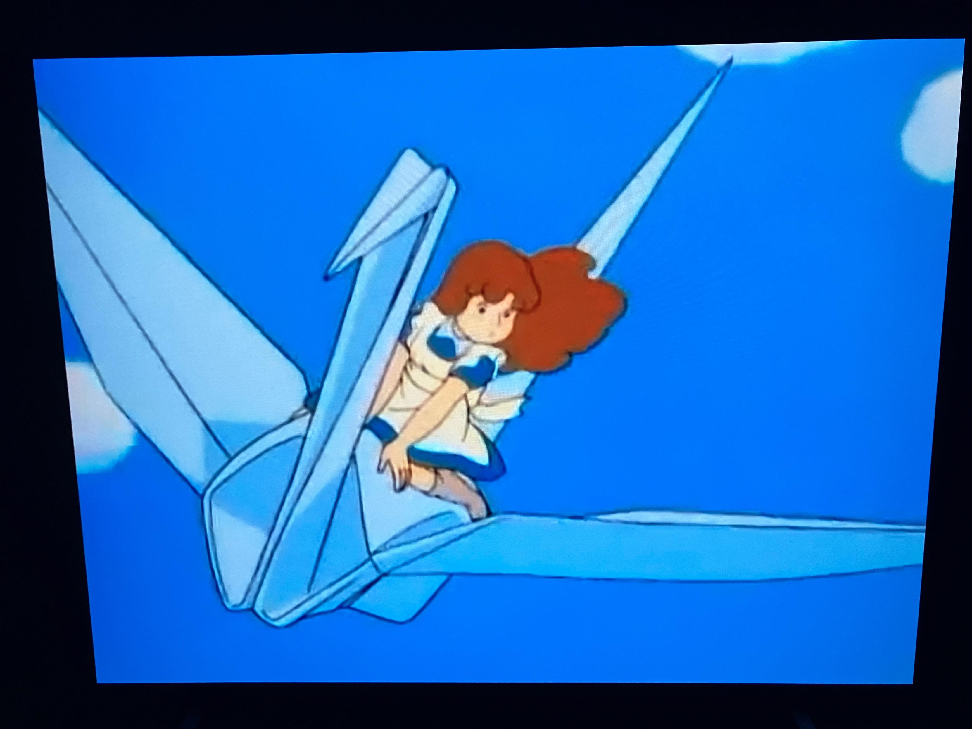 Sn anime girl riding a giant origami bird.