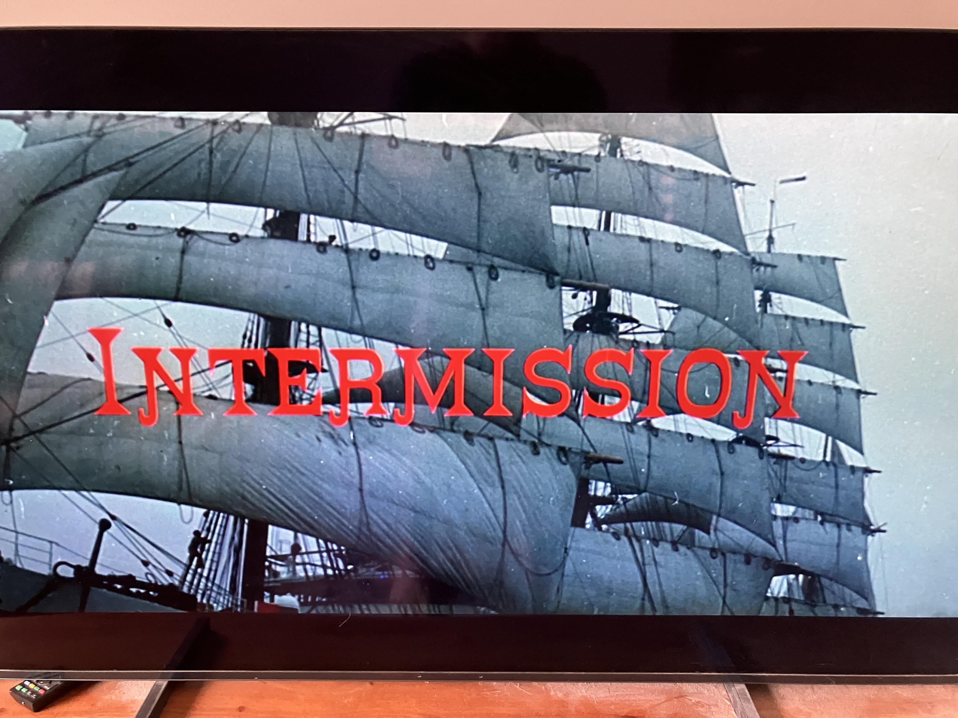 Photo of a TV showing around the world in 8 days. A large sailing ship is on screen with the words INTERMISSION in red.